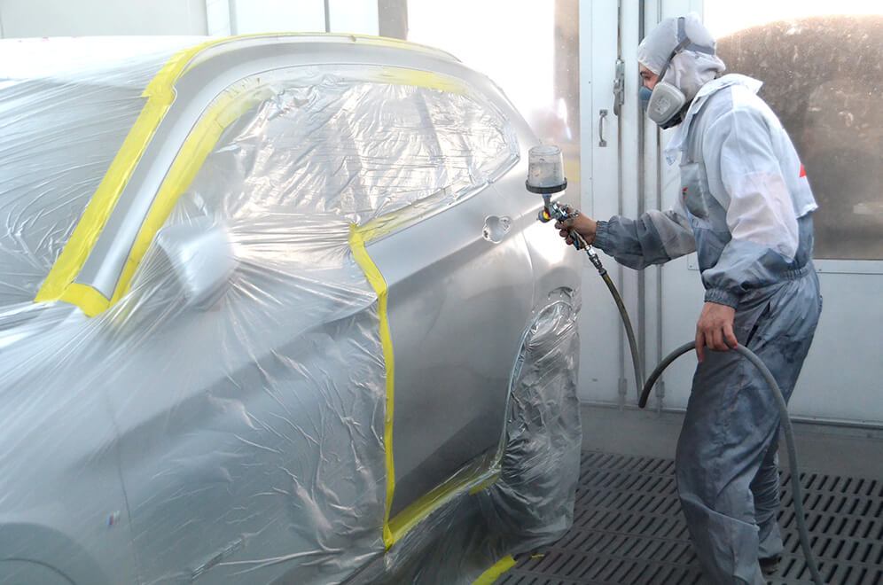 Spray painting a panel in the booth